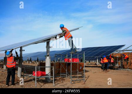 ZHANGYE, CHINA - NOVEMBER 15, 2022 - Workers speed up installation of photovoltaic panels at the construction site of the solar power generation proje Stock Photo