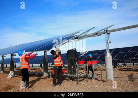 ZHANGYE, CHINA - NOVEMBER 15, 2022 - Workers speed up installation of photovoltaic panels at the construction site of the solar power generation proje Stock Photo