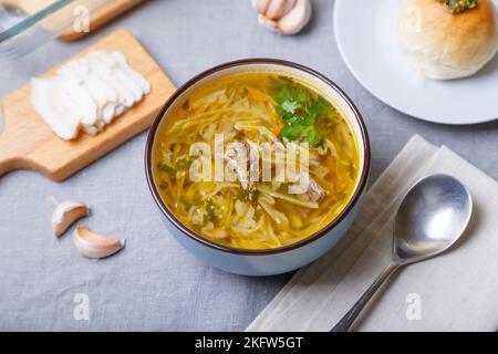 Shchi with pampushki (buns) and lard. Soup of cabbage, potatoes and meat. Traditional Russian and Ukrainian cuisine. Close-up. Stock Photo