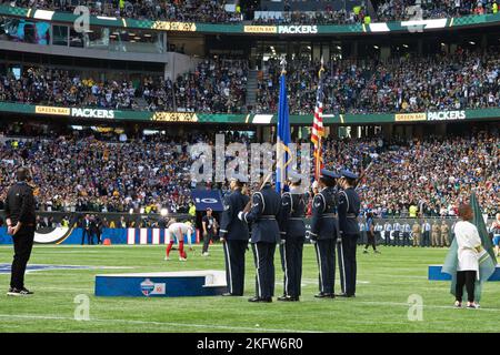 U.S. Air Force Staff Sgt. Michelle Doolittle, U.S. Air Forces in Europe Band vocalist, stands in front of the 48th Fighter Wing Honor Guard before singing the U.S. National Anthem during the pre-game ceremony of the National Football League’s New York Giants vs. Green Bay Packers game at Tottenham Hotspur Stadium, in London, England, Oct. 9, 2022. As part of the pre-game ceremony, Airmen presented a U.S. Flag alongside a U.K. flag presented by British service members. The Giants defeated the Packers 27-22. Stock Photo