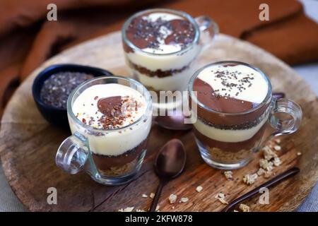 Healthy desserts in mugs. Vanilla and chocolate puddings with chia seeds and linseeds. Stock Photo