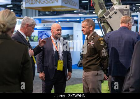 Sgt. Maj. of the U.S. Army Michael A. Grinston, listens as John P. Chadbourne, executive vice president and chief of business development officer and government relations, AM General, briefs on military vehicles on display in one of the exhibit halls at the Association of the United States Army 2022 Annual Meeting and Exposition at the Walter E. Washington Convention Center in Washington, D.C., Oct. 10, 2022. More than 600 exhibitors showcased their products in services across five exhibit halls. AUSA 2022,Allies and Partners,NATO,People First,StrongerTogether, Stock Photo