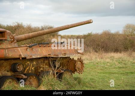 an abandoned rusting British FV4201 Chieftain main battle tank wreck in afternoon sunlight Stock Photo