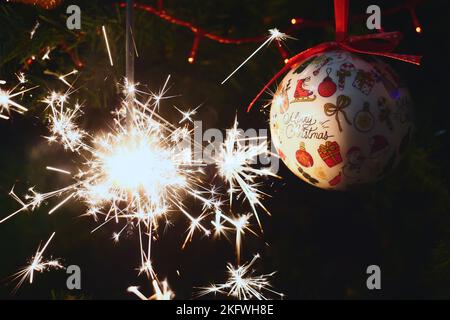 Sparkler burning on a Christmas tree.Christmas tree decoration and sparkler close-up Stock Photo