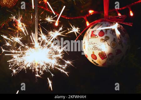 Sparkler burning on a Christmas tree.Christmas tree decoration and sparkler close-up Stock Photo