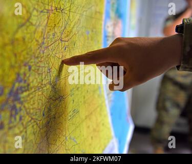 U.S. Air Force Airman 1st Class Owen Arthur, 316th Training Squadron student, points at a map in a simulated joint operations center for his capstone exercise, Operation Loneshark, at Goodfellow Air Force Base, Texas, Oct. 11, 2022. Students used maps in the capstone to help visualize world information. 316 TRS,Department of Defense,Operation Loneshark,discipline springs from the people,joint operations center, Stock Photo