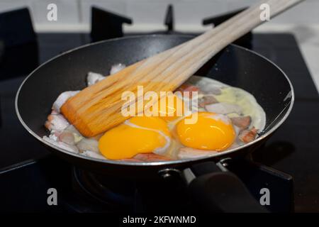 Scrambled eggs with bacon in a pan. Stock Photo