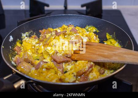 Scrambled eggs with bacon in a pan. Stock Photo