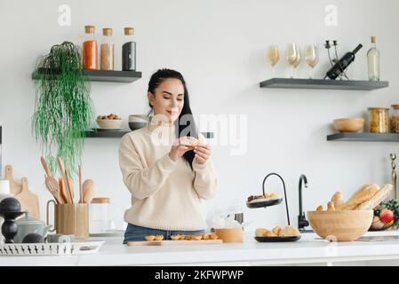 A cheerful woman does her favorite thing at home. Business at home. Remote shipping and small business production Stock Photo