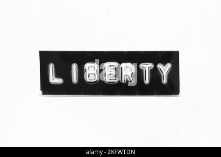 Black color banner that have embossed letter with word liberty on white paper background Stock Photo