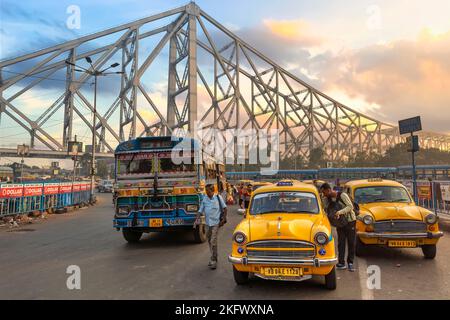 Public transport vehicles on city road near historic Howrah bridge Kolkata, India at sunrise.. Stock Photo