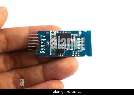 A ZS-042 RTC (Real Time Clock) module held in hand. This module is used for electronics hobbyists for DIY materials. Stock Photo