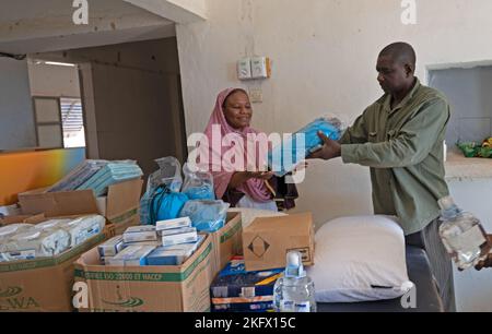 AGADEZ, Niger - A member of the Niger Armed Forces - Affair Civil Militaire (FAN ACM) hands out donations to a local women’s clinic in Agadez, Niger, Oct. 12, 2022. The 443rd Civil Affairs Battalion members collaborate with FAN ACM to work with local villages to increase continuity between the military rotations. Stock Photo