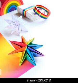 Vibrant neon rainbow origami paper stars. LGBTQ community rainbow flag colors. handmade DIY Christmas decor, copy-space. Self made Xmas stars made Stock Photo