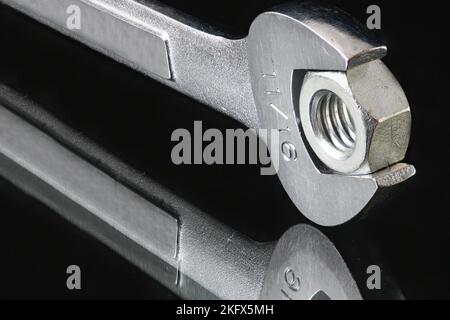 Open End Wrench and Nut on dark background Stock Photo