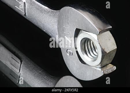 Open End Wrench and Nut on dark background Stock Photo