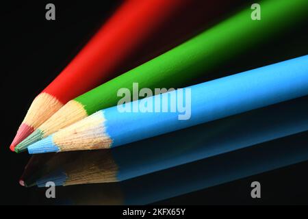 Bright Colored pencils on dark reflective glass Stock Photo