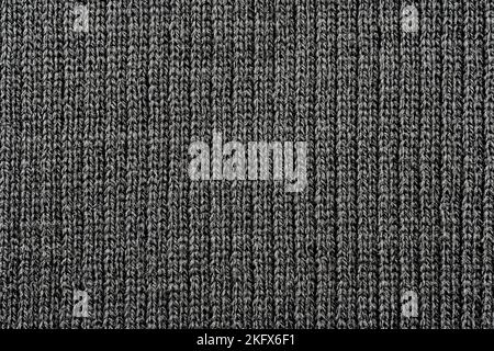 Texture of knitted fabric in dark color. Knitted material background Stock Photo