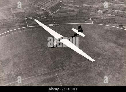 A glider soars over the countryside of Piedmont (Italy) in mid fifties Stock Photo