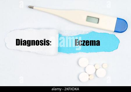 Medical diagnosis. A gap is made in the middle of the white sheet, inside of which there is an inscription - Eczema on a blue background. On the sheet Stock Photo