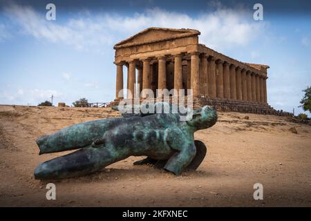 Bronze statue lying at the front of the ancient Greek Concordia temple in the Valley of the Temples. Agrigento. Sicily. Italy. Stock Photo