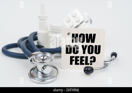 Medical concept. On a white surface, medicines, a stethoscope and writing paper with the text - How Do You Feel Stock Photo