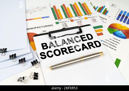 Business concept. On the table among financial graphs and charts lies a tablet with the inscription - BALANCED SCORECARD Stock Photo