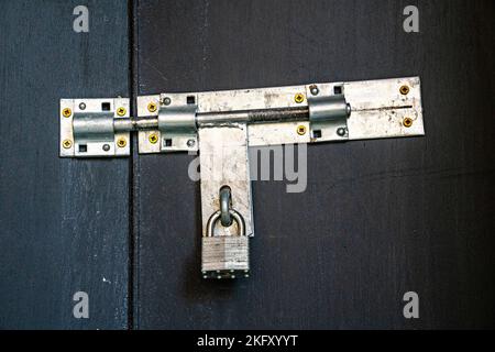 Padlock securing steel bolt on gates Stock Photo