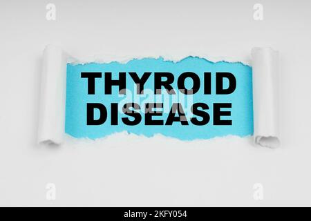 Medical concept. In the middle of a white sheet in space on a blue background the inscription - THYROID DISEASE Stock Photo