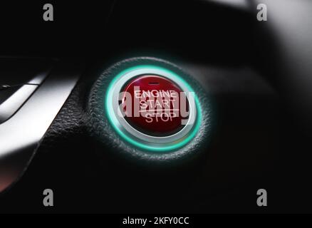 The electric car engine start stop button is illuminated by a green light Stock Photo