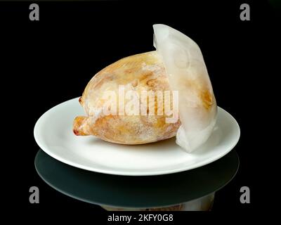 Game Hen frozen on a white plate with black background Stock Photo