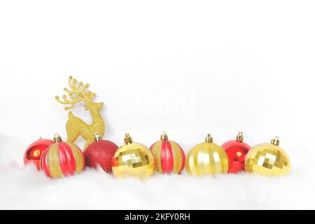 Merry Christmas decorated with Christmas balls and golden deer on the white fur carpet,copy space on white background Stock Photo