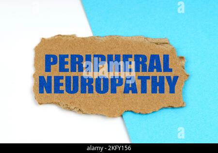 Medicine and health concept. On a blue and white background lies a piece of cardboard with the inscription - PERIPHERAL NEUROPATHY Stock Photo