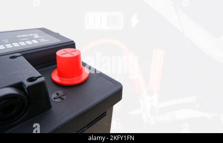Red positive terminal of a generic car black battery and battery recharge double exposure on a white background with copy space Stock Photo