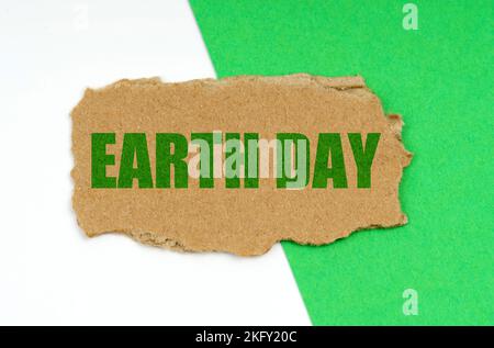 Environmental concept. On a white-green background lies a piece of cardboard with the inscription - earth day Stock Photo