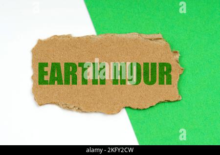 Environmental concept. On a white-green background lies a piece of cardboard with the inscription - Earth Hour Stock Photo