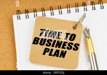 Business and economy concept. There are two notebooks and a pen on the table. On the top notepad, the inscription - Time To Business Plan Stock Photo