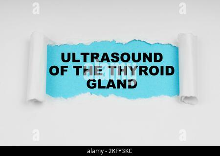 Medical concept. In the middle of a white sheet in space on a blue background the inscription - Ultrasound of the thyroid gland Stock Photo