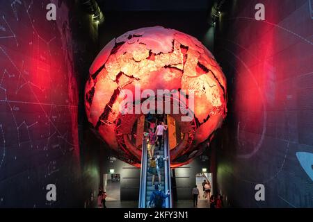 The visitors taking an escalator to the Earth Hall through a red globe in the Natural History Museum, London Stock Photo