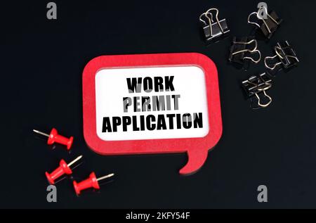 Economy and business concept. On a black surface, office supplies and a red plaque with the inscription - Work permit application Stock Photo