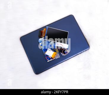 Electronics waste including a lcd screen,a electronic board,a battery,a camera lens and tablet computor on white fur rug background Stock Photo