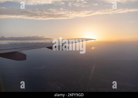 Airplane flight. Aircraft's wing and land seen through the illuminator Stock Photo