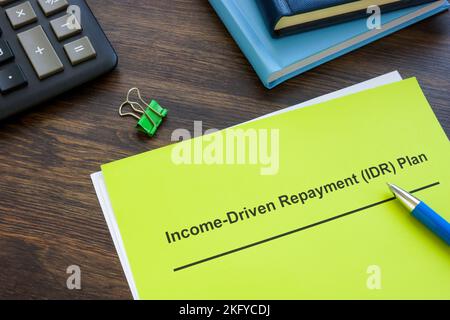 Income driven repayment IDR plan near calculator and notepads. Stock Photo