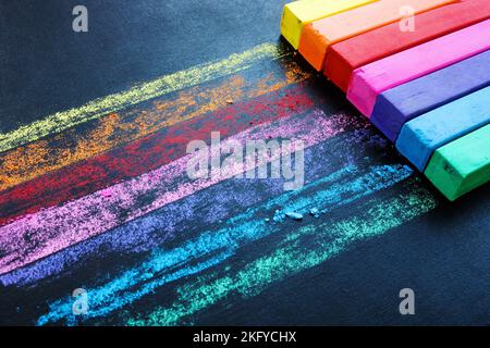 Multi-colored crayons on a black board as a symbol of creativity. Colorful background. Stock Photo