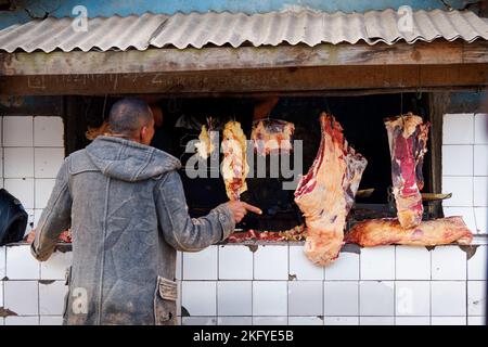 Street butchery stall in Malagasy village in Madagascar, food butcher shop with the fresh meat,  flies on the meat, typical view from the street in Af Stock Photo