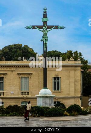 A woman looking at the statue of the crucifixion of Christ in Montpelier, France. Stock Photo