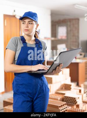 Female foreman working with laptop in building under construction Stock Photo