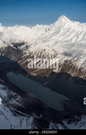 An aerial view down onto the Tasman glacial Lake with Mount Sefton towering over it in Mount Cook National Park, New Zealand. Stock Photo