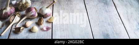 Garlic bulbs and cloves on wooden table, food background, copy space Stock Photo