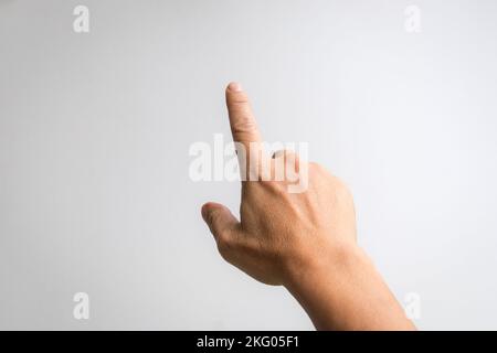 Male hand with index finger pointing to something. White background. Stock Photo